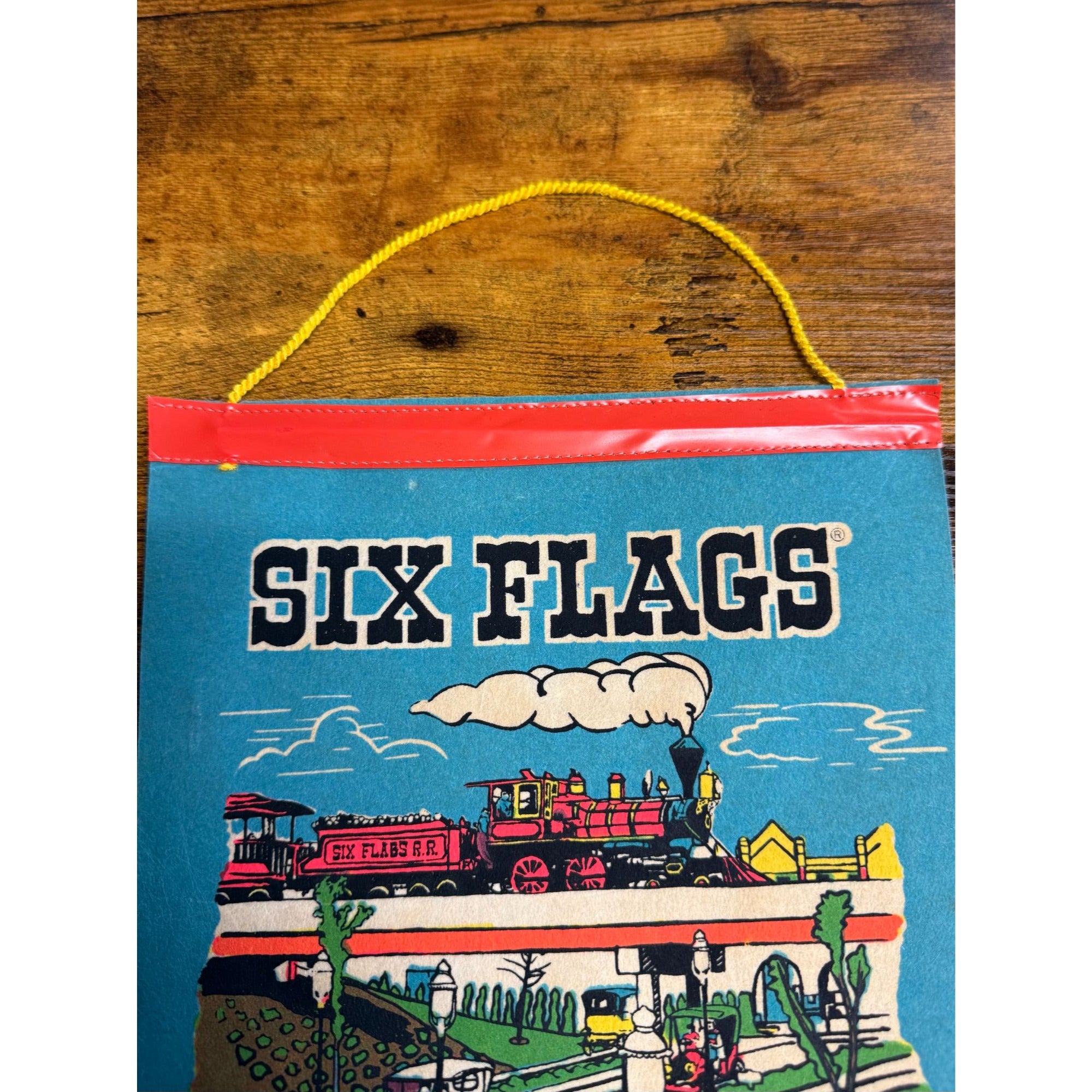 Vintage Six Flags Over Mid-America Hanging Souvenir Colorful Train & Park Scene On Blue Background With Yellow Cord