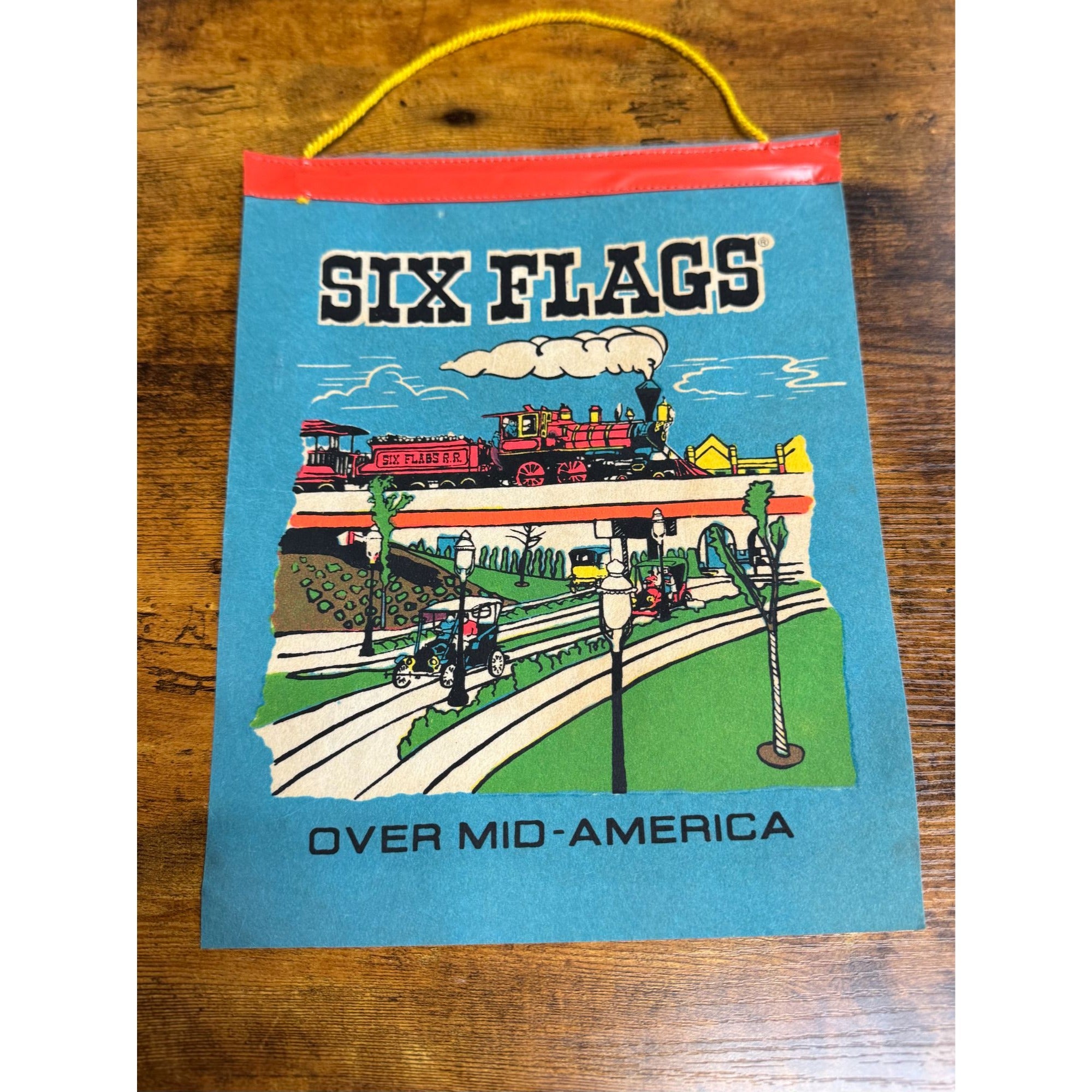 Vintage Six Flags Over Mid-America Hanging Souvenir Colorful Train & Park Scene On Blue Background With Yellow Cord